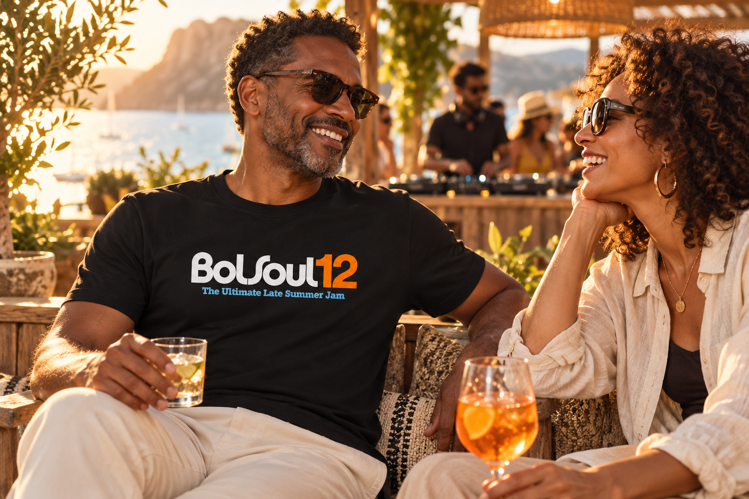 Friends on a sunlit seaside terrace, with a black BolSoul12 T-shirt at the heart of the scene